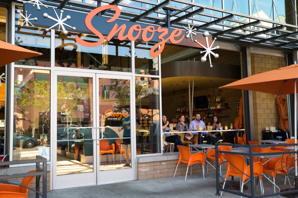 An Exterior Photo Of The Snooze Restaurant & Patio In Hillcrest Showing The Snooze Sign