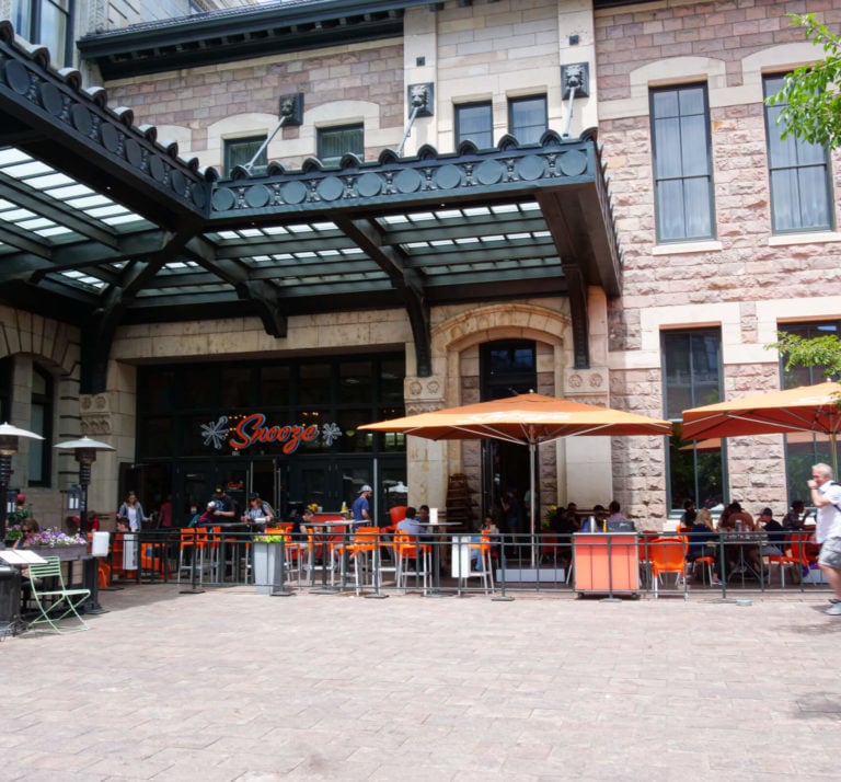An Exterior Photo Of The Snooze Restaurant & Patio At Union Station Showing The Snooze Sign
