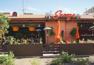 An Exterior Photo Of A Snooze Restaurant & Patio Showing The Snooze Sign