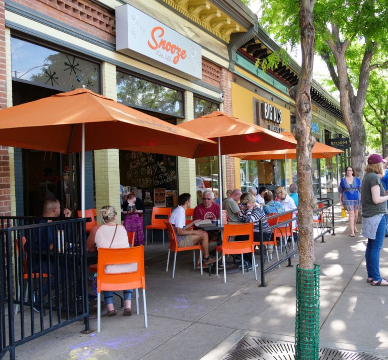 An Exterior Photo Of The Snooze Restaurant & Patio In Fort Collins Showing The Snooze Sign