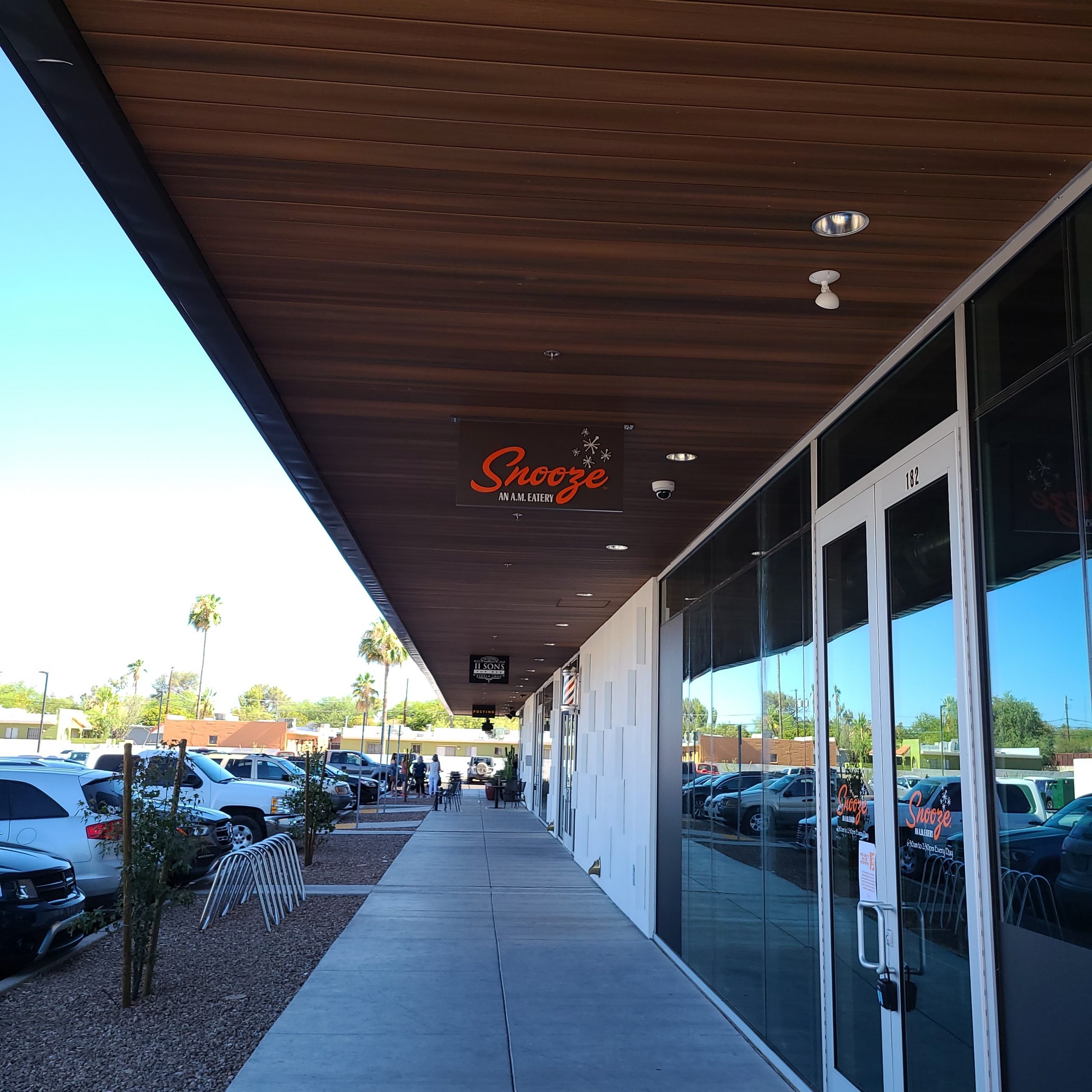 Exterior Photo Of The Snooze Restaurant & Patio In Tucson Showing The Snooze Sign & Front Door