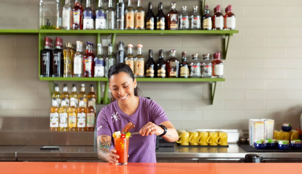 Barista serving a bloody mary at the bar