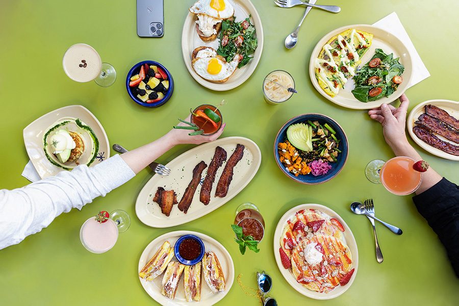 A selection of signature Snooze brekfast dishes on a green tabletop